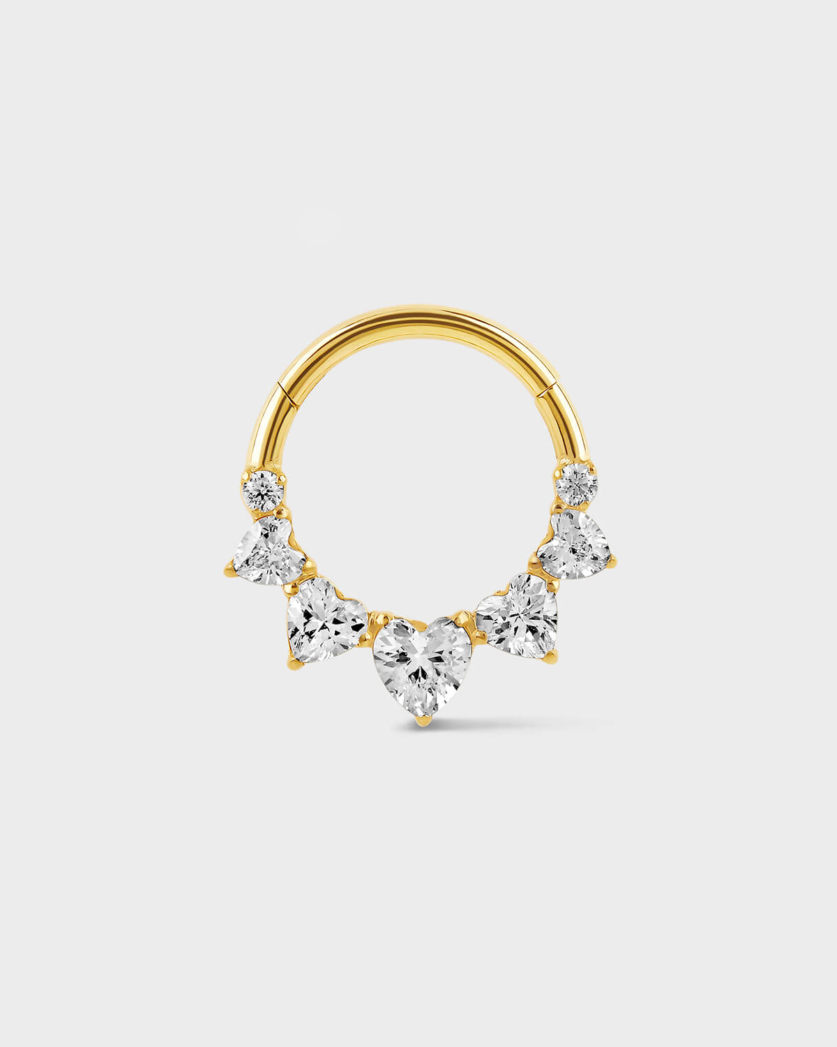 Gold titanium Daith or septum ring with five graduated heart shape gems and two smaller round gem sat on a light gray background