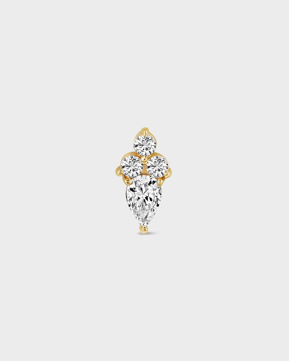 Gold and diamond earring on a light gray background