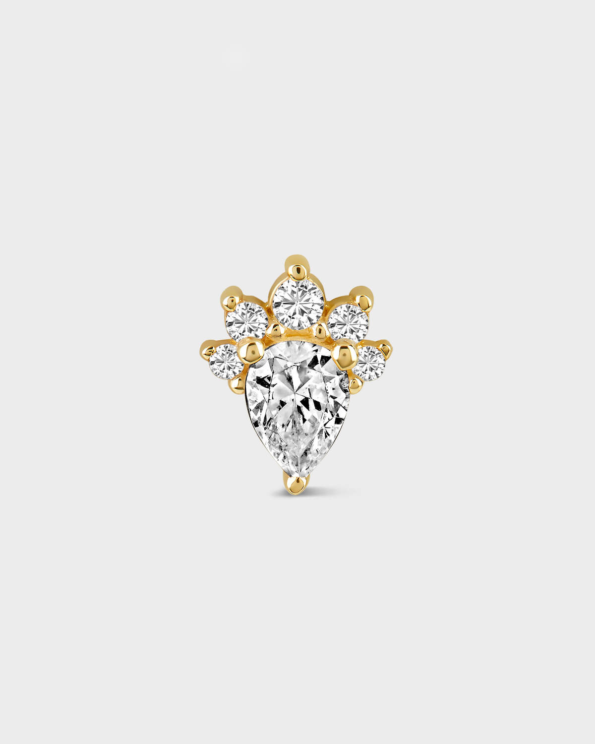 Gold and diamond earring on a light gray background