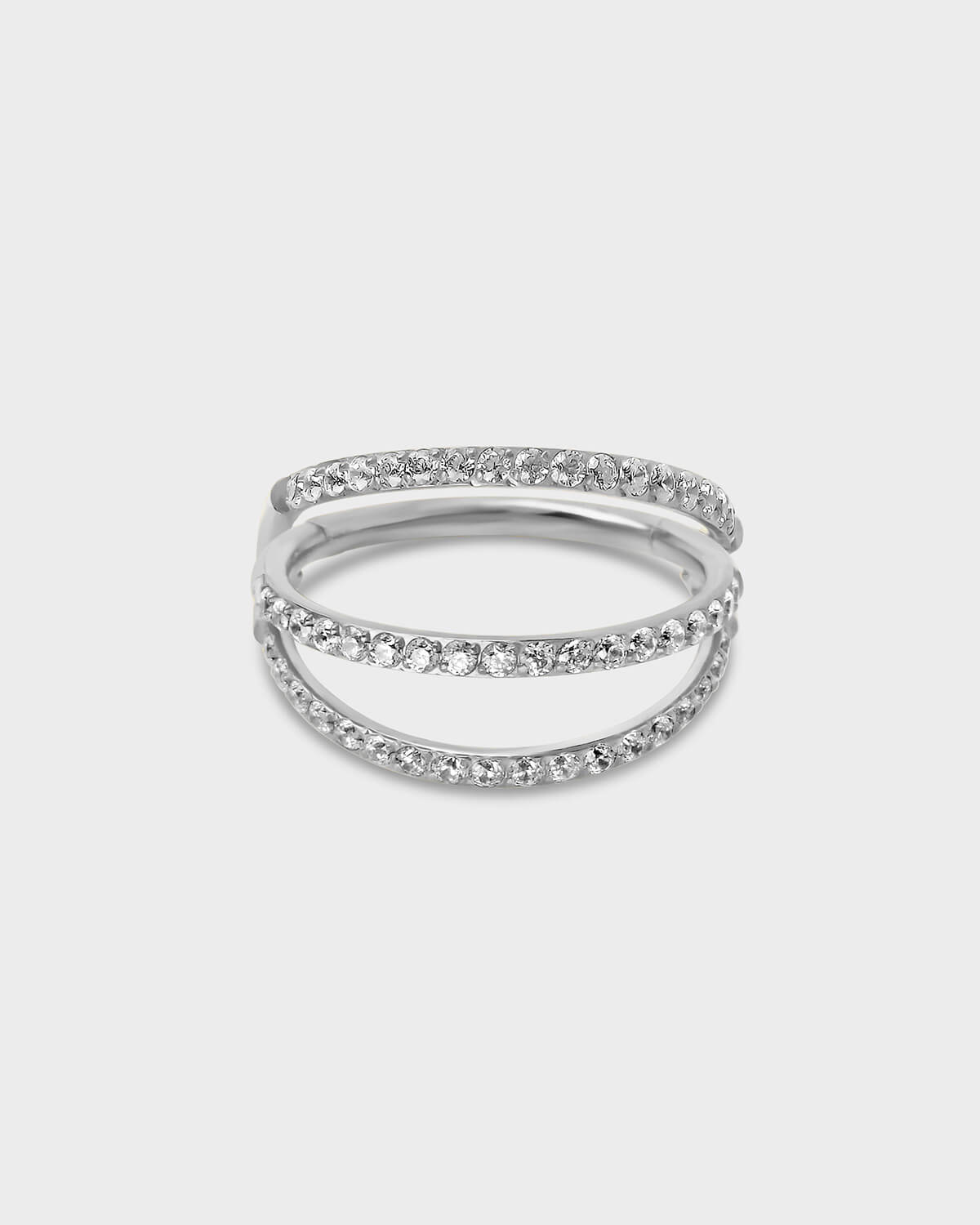 Polished Silver titanium triple stack pave ring with clear gemstones on a light gray background.