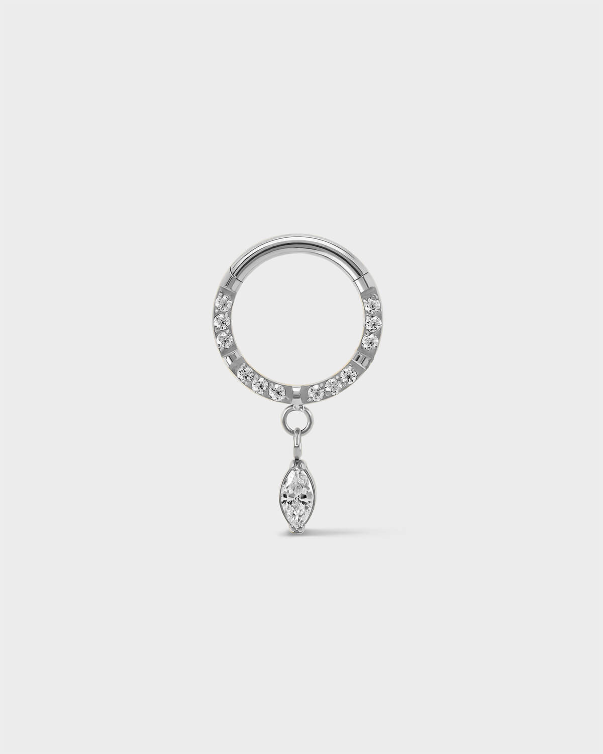 Semi pave polished silver titanium daith septum ring with a marquise dangle charm sat on a light gray background.