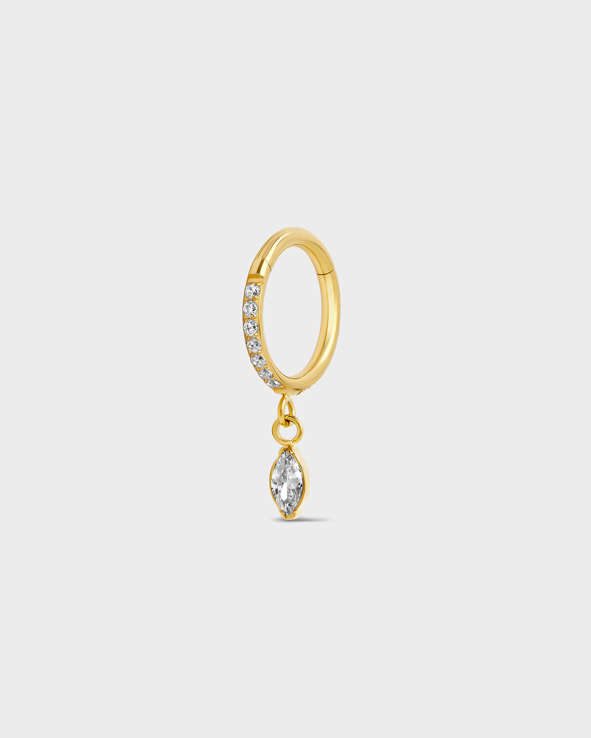 Gold titanium hinged ring with clear pave gemstones around the outer edge and a single dangle marquise charm sat on a light gray background.