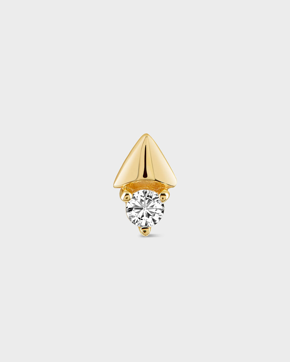 Gold earring with a clear gemstone on a light gray background