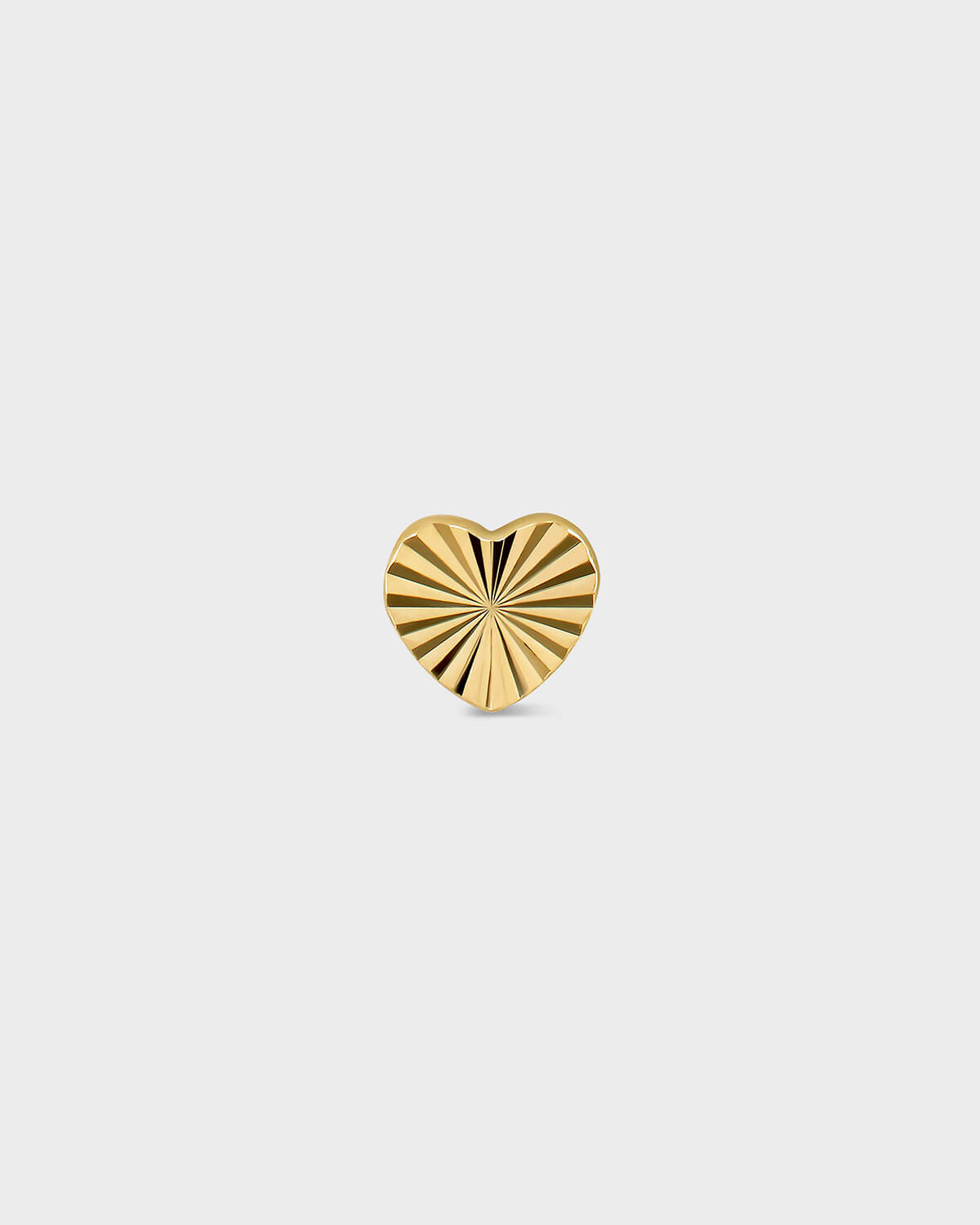 Gold heart-shaped pendant with sunburst design on a light gray background
