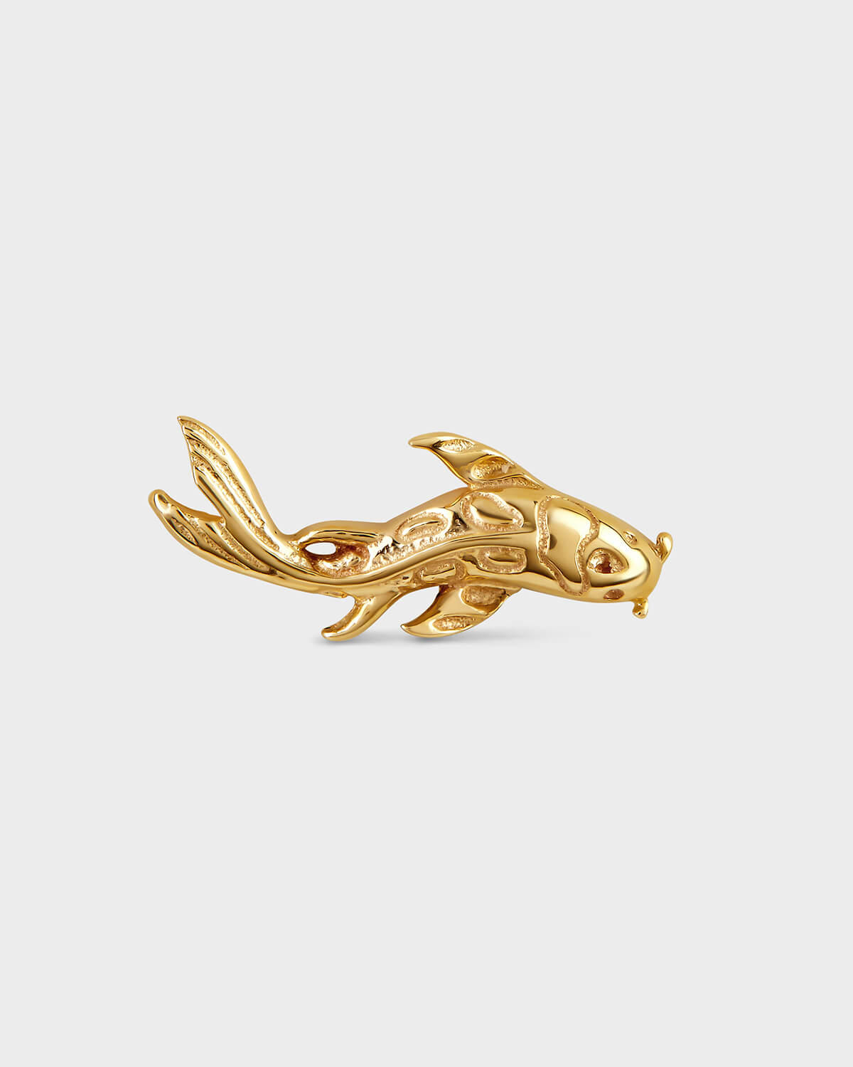 Gold koi-shaped earring on a light gray background
