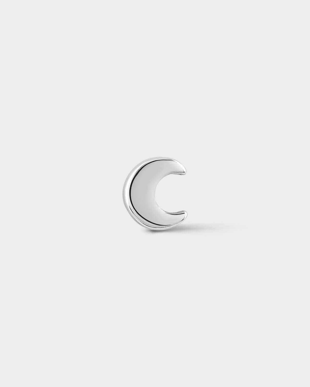 White gold moon-shaped earring on a light gray background