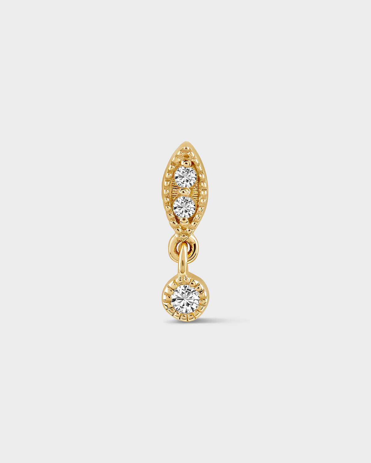 Gold earring with two diamond drops on a light gray background