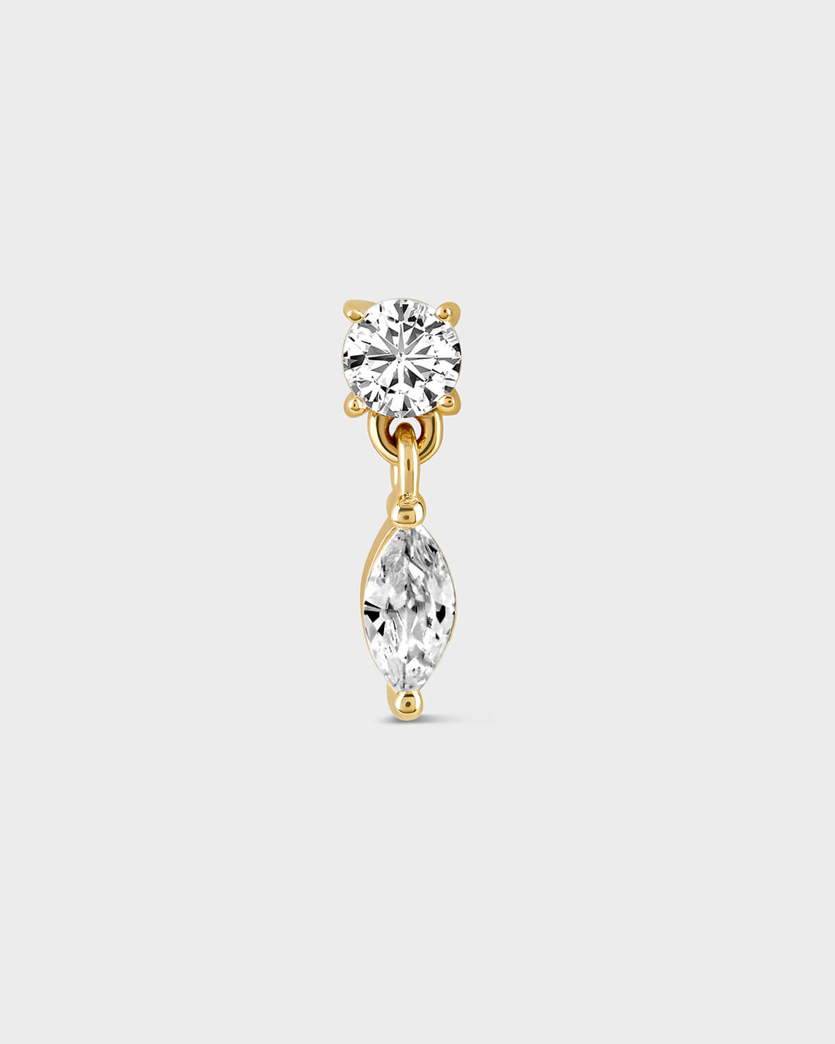 Gold earring with solitaire gemstone and a dangling marquise stone on a light gray background
