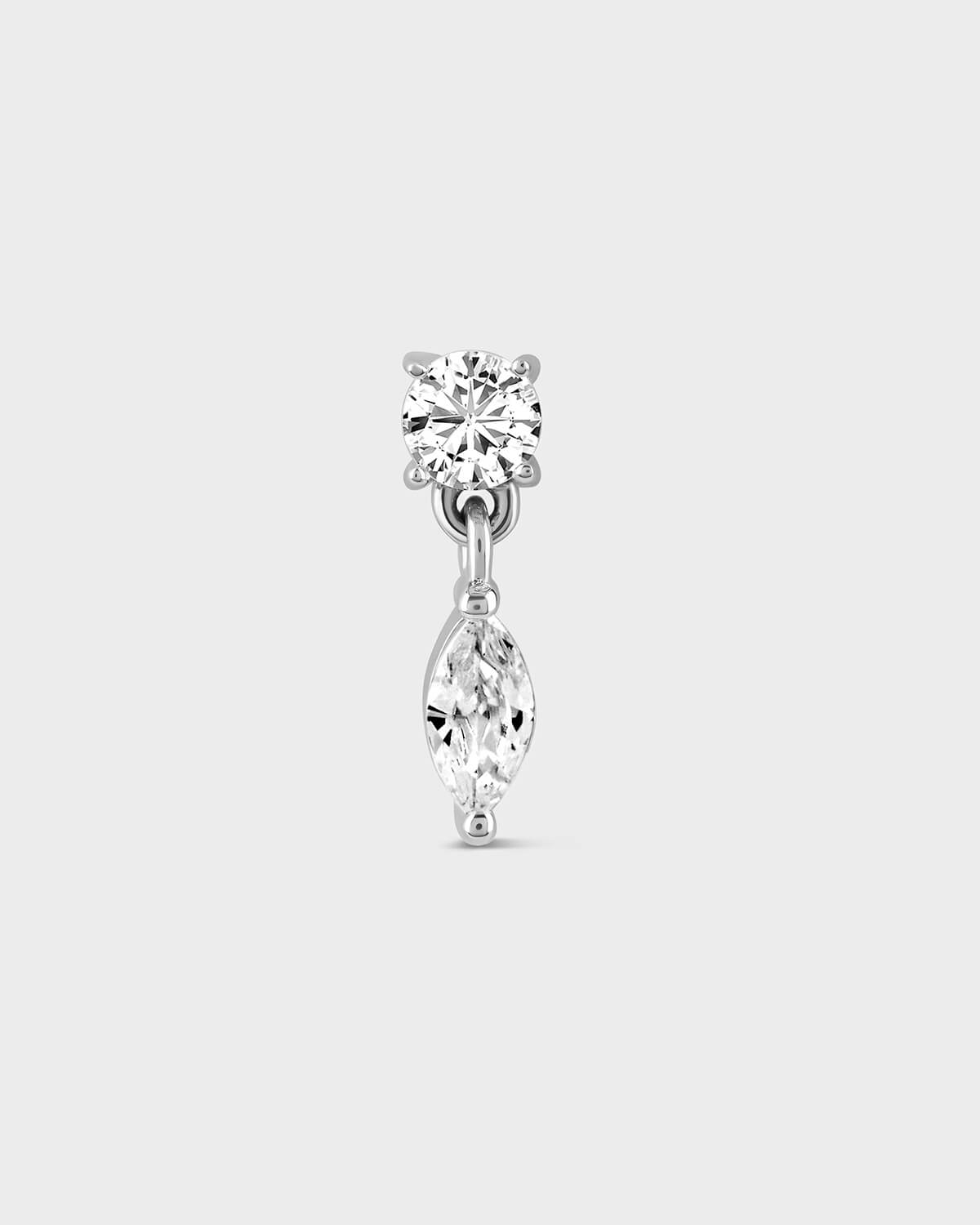 White gold earring with solitaire gemstone and a dangling marquise stone on a light gray background