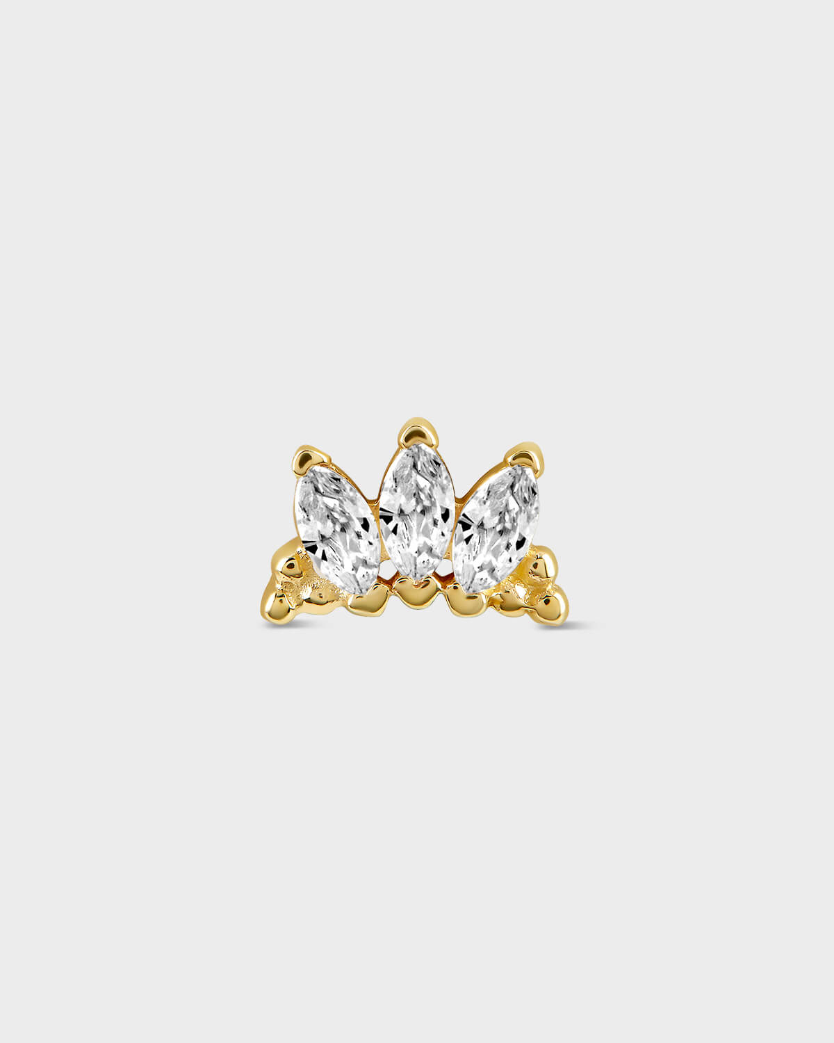 Gold earring with three clear gemstones on a light gray background