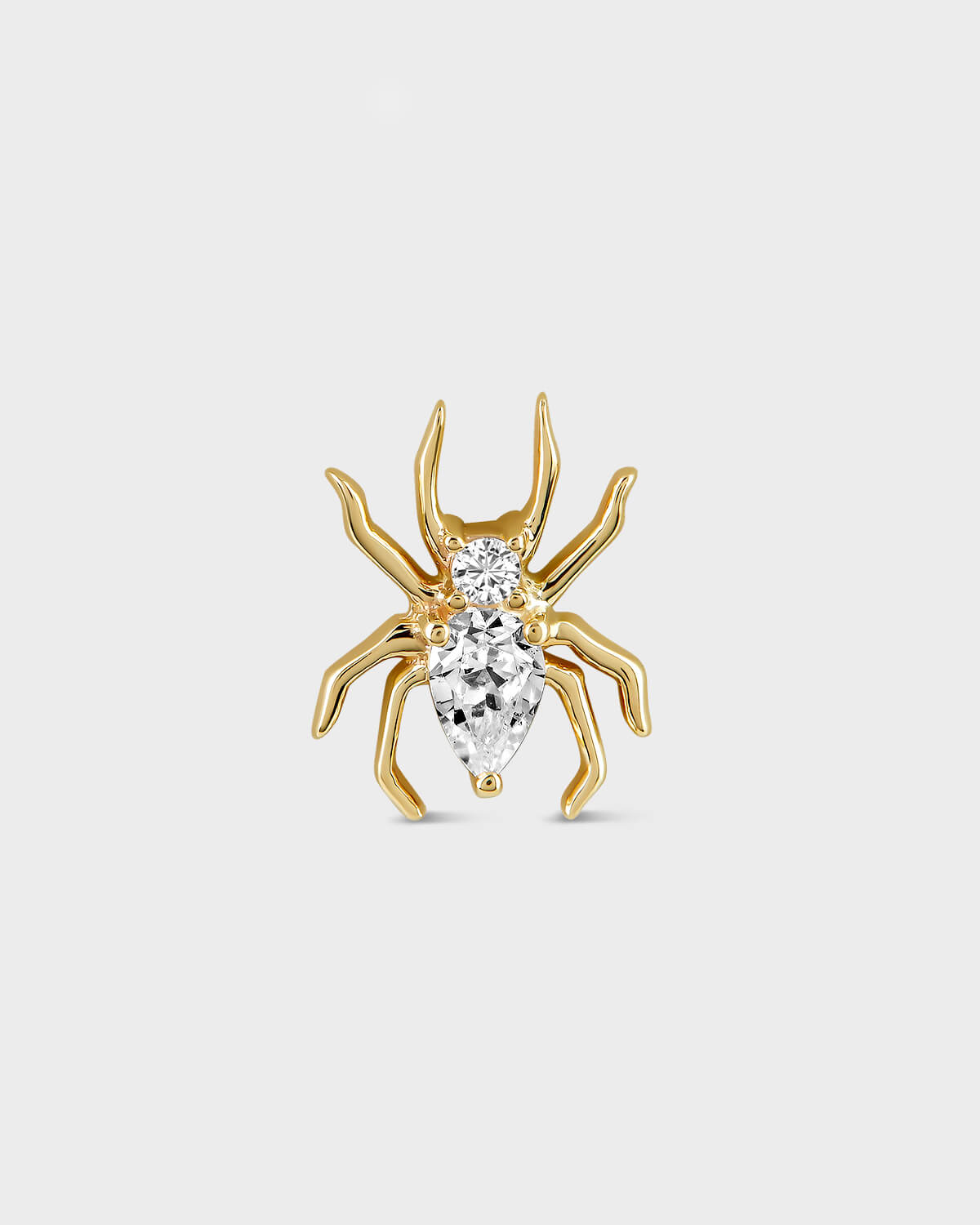 Gold spider-shaped earring with clear gemstones on a light gray background