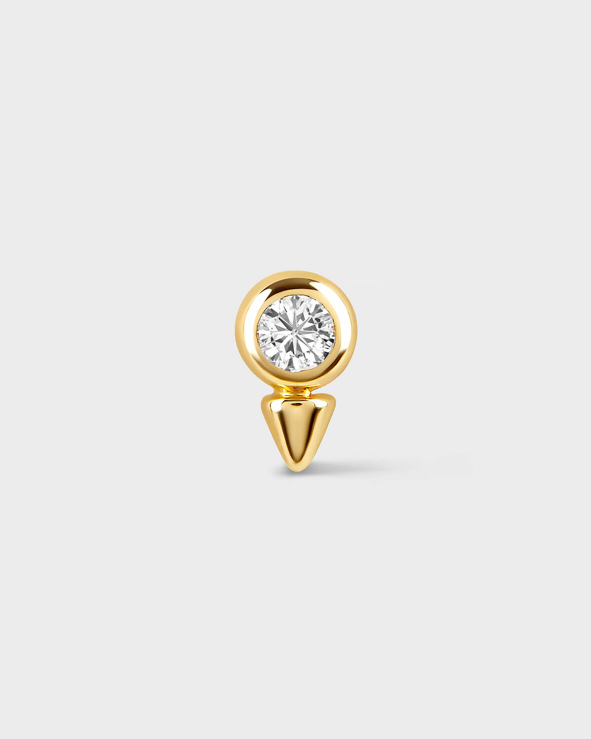 Gold earring with a diamond on a light gray background