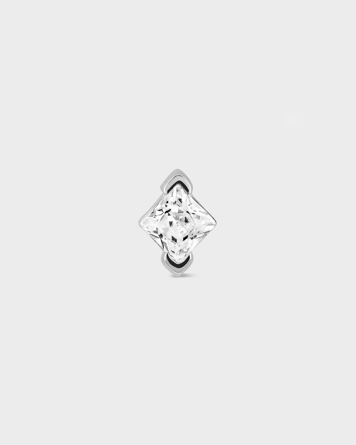 Single stud earring with a clear gemstone on a light gray background